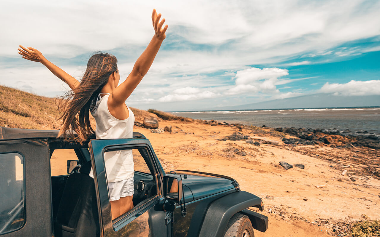 Woman throwing her arms up and stepping out of a vehicle 