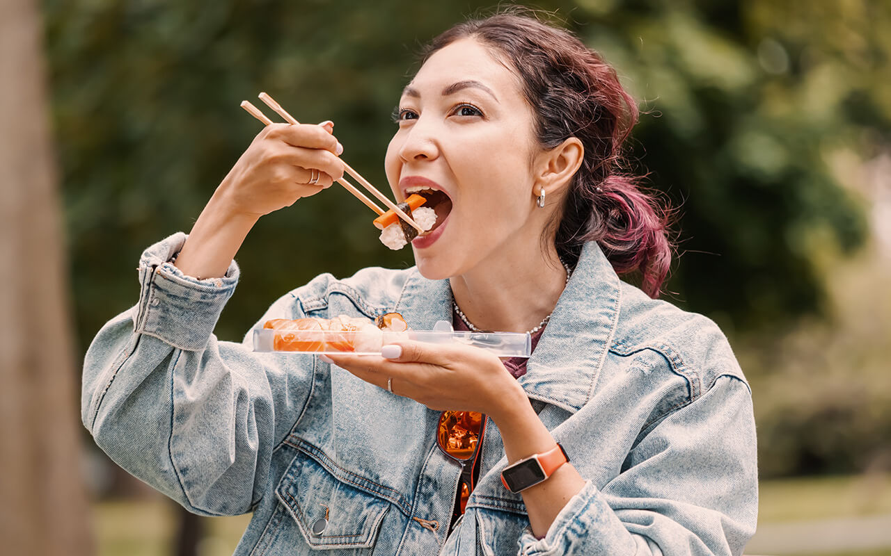 Woman eating sushi in public