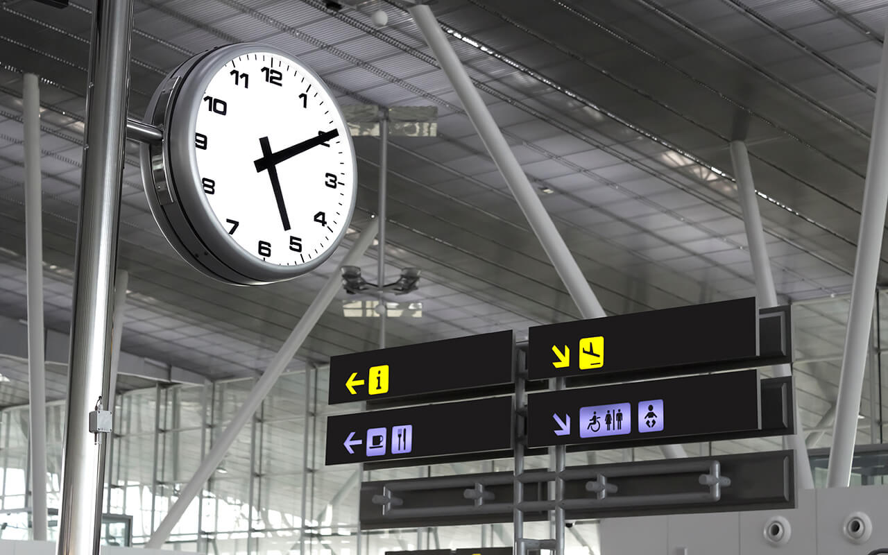 Clock and signs at an airport