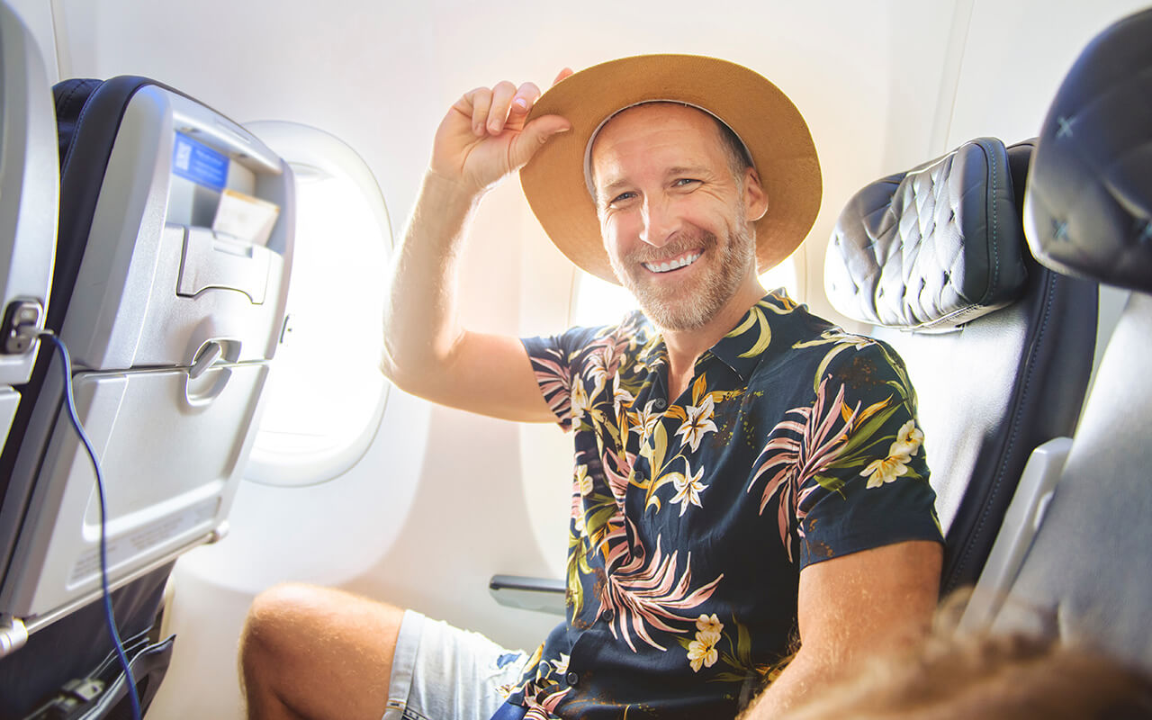 Man in a floral shirt on an airplane