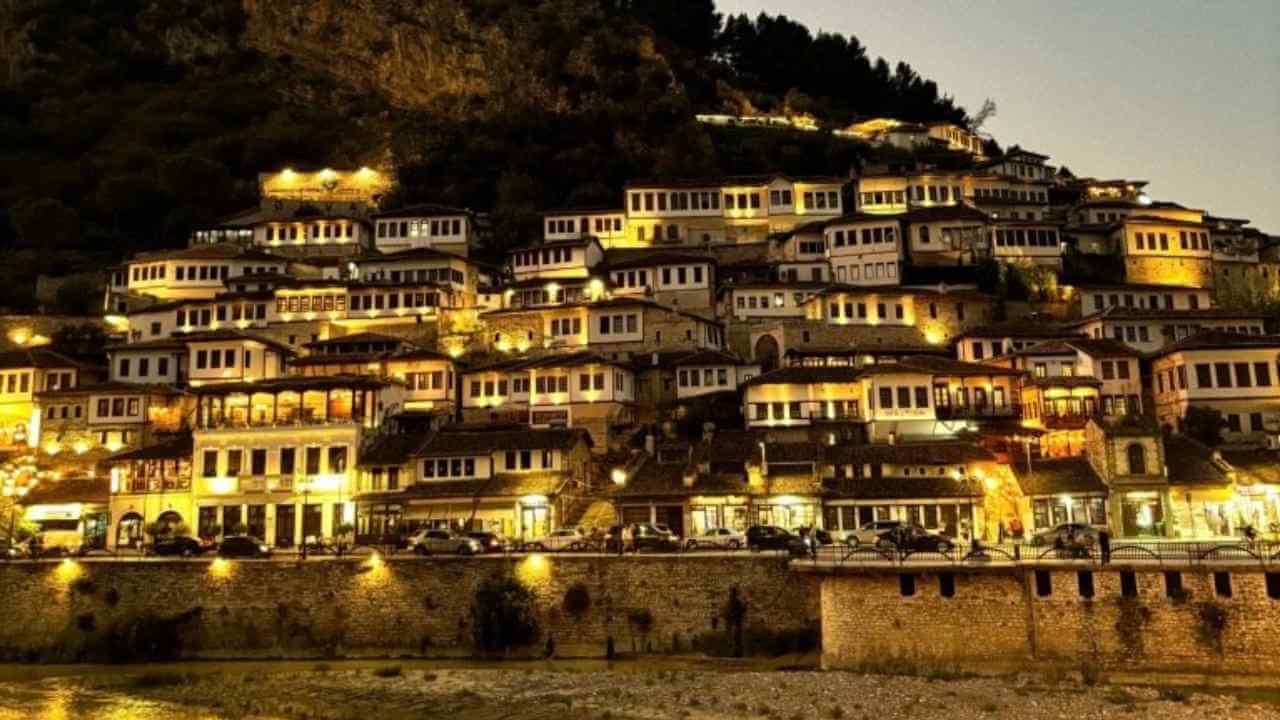 a city lit up at night on the side of a mountain