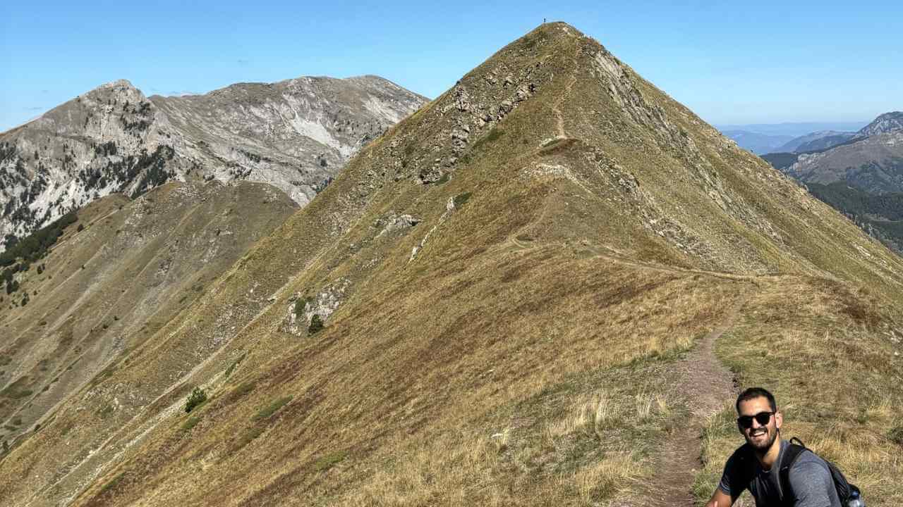 a person standing on top of a mountain with mountains in the background