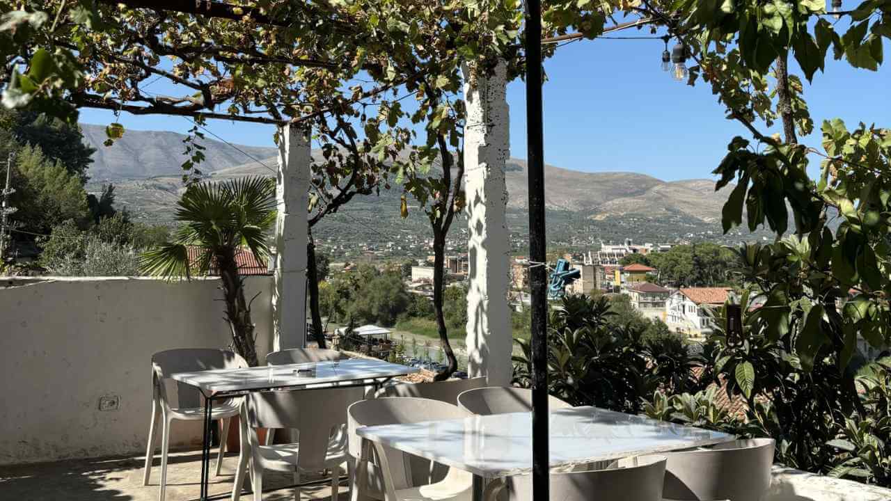 a patio with tables and chairs overlooking the mountains