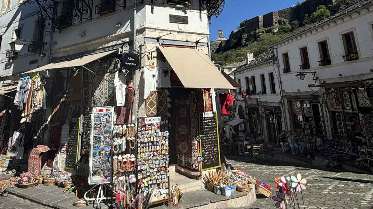 a narrow cobblestone street with shops on both sides