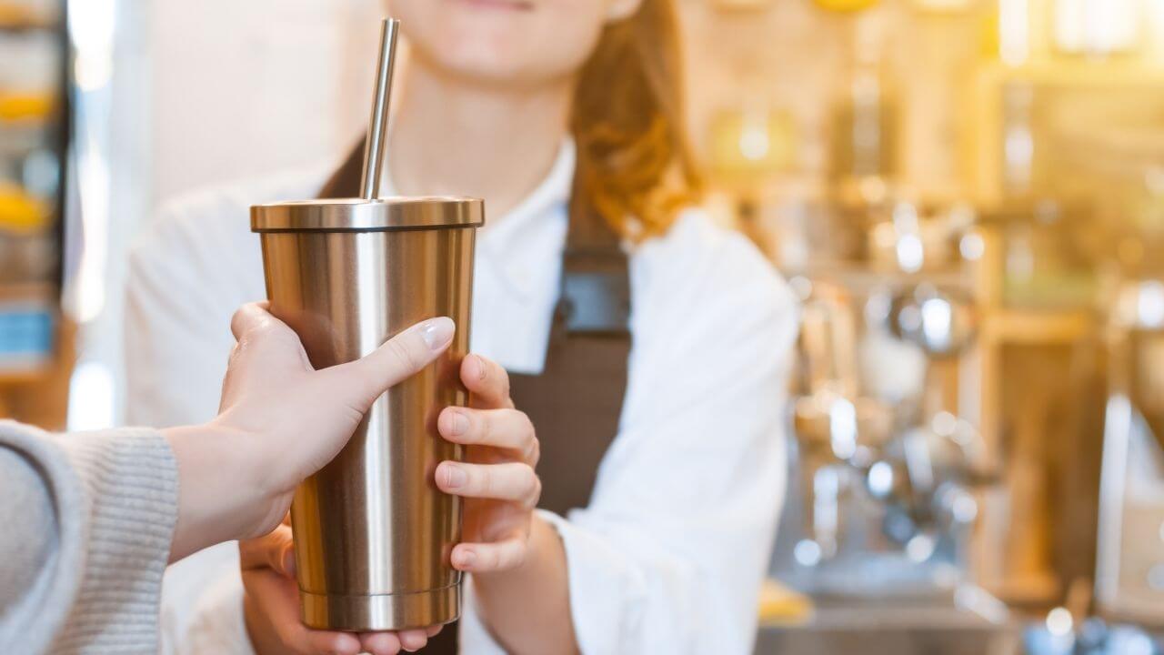 a person is holding a cup with a straw in it