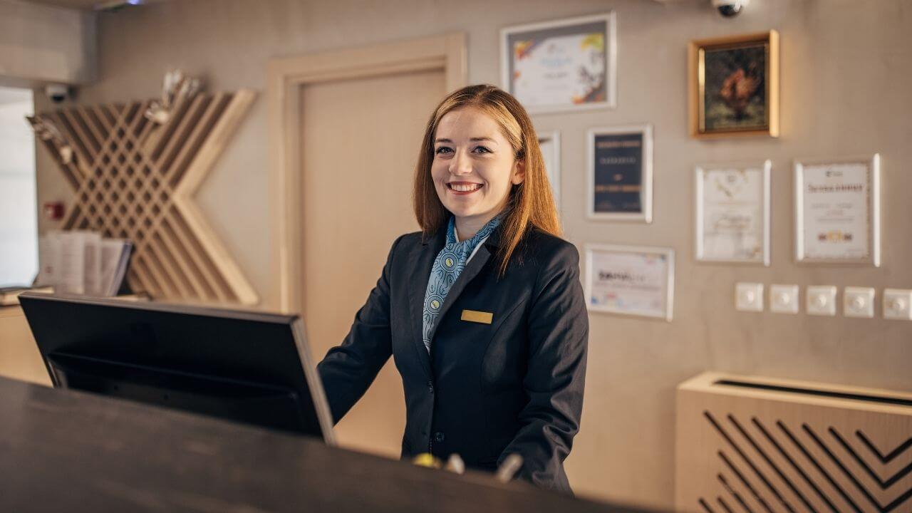 a person in a business suit standing at the front desk of a hotel