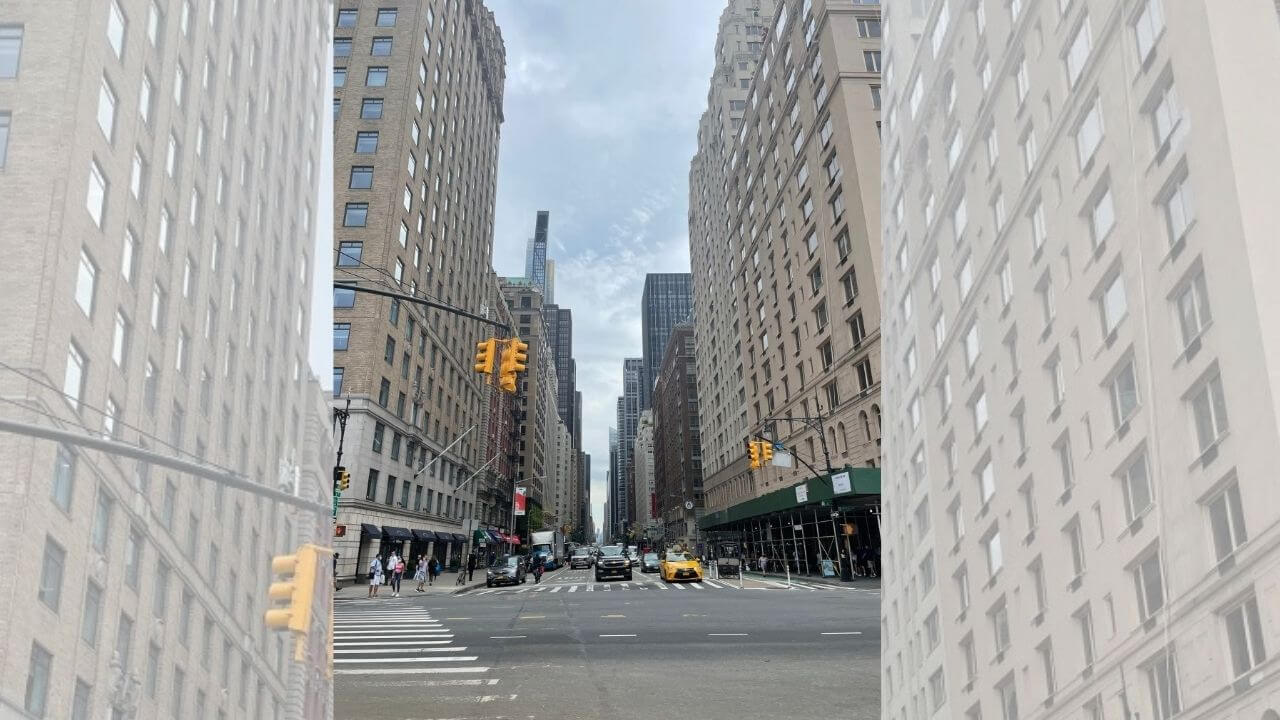 an empty street in new york city with tall buildings and traffic lights