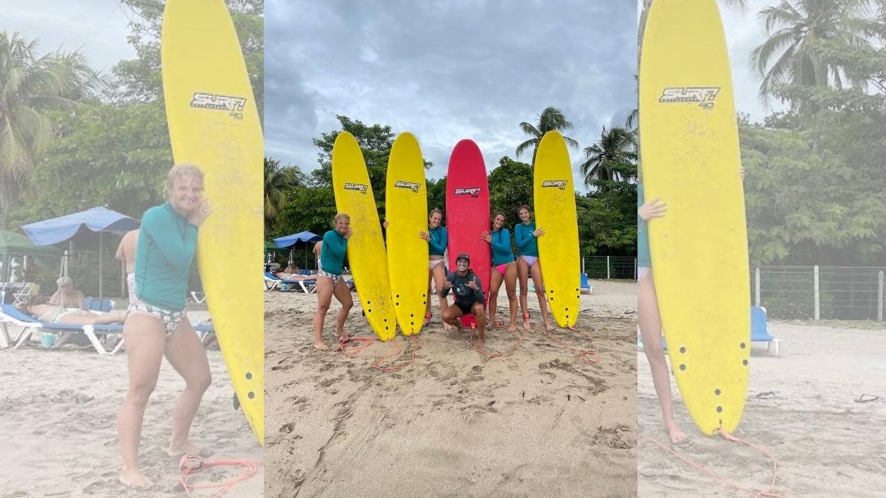 a group of people posing with surfboards on the beach