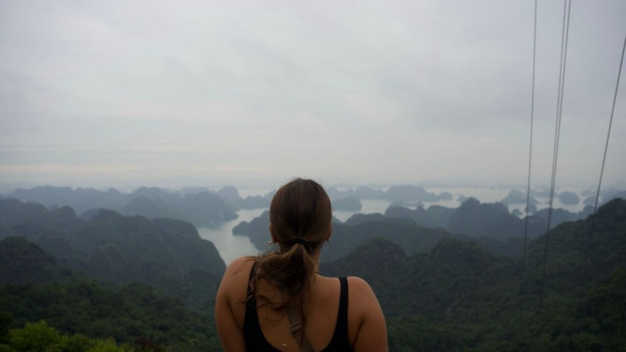 a person looking out over the ocean from the top of a mountain