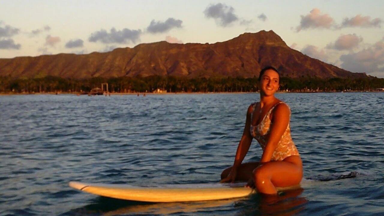 a person sitting on top of a surfboard in the ocean