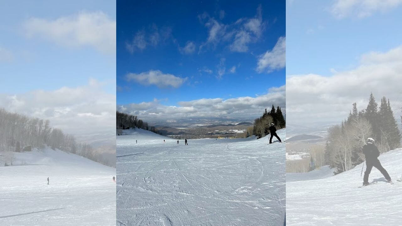 people are skiing on a snowy slope under a blue sky