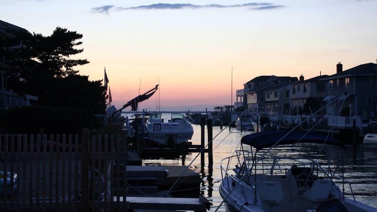 boats are docked in the water at sunset