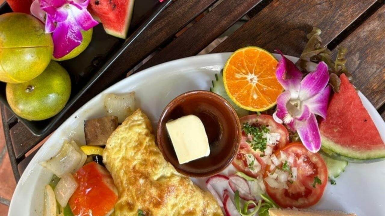 an omelet on a plate with fruit and vegetables