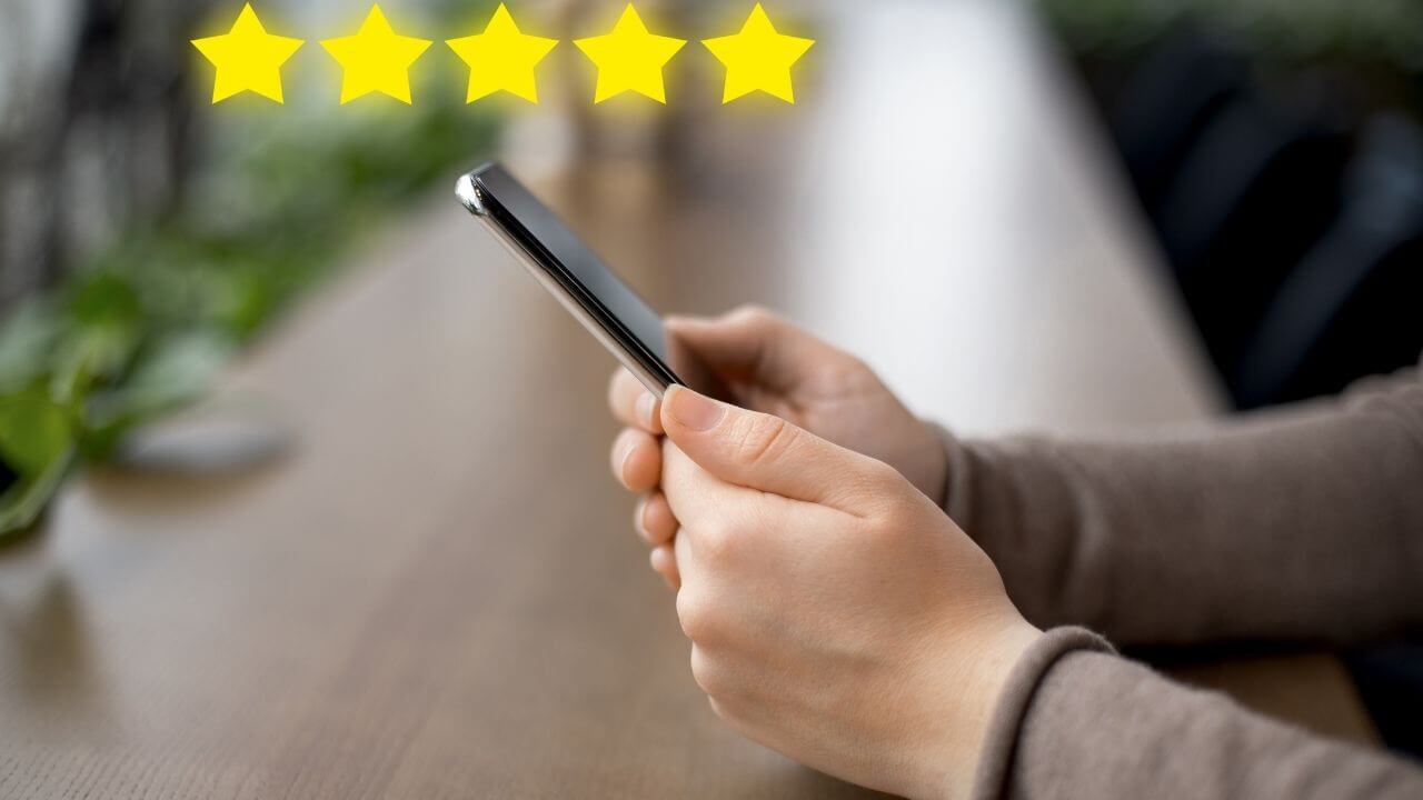 a person holding a cell phone with five stars on it