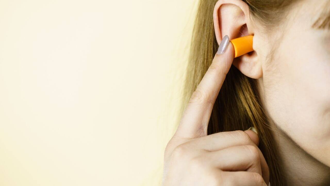 a person with an orange ear plug in their ear