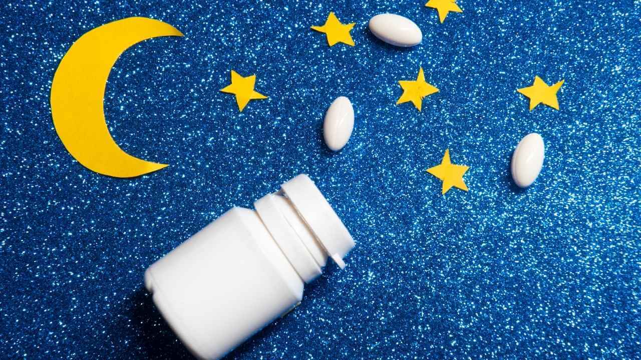 a bottle of pills and a crescent moon on a glittery blue background