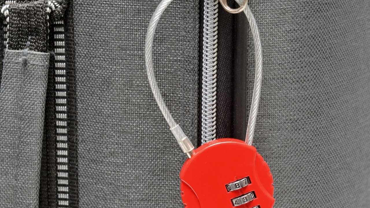 a luggage lock with a red key attached to it