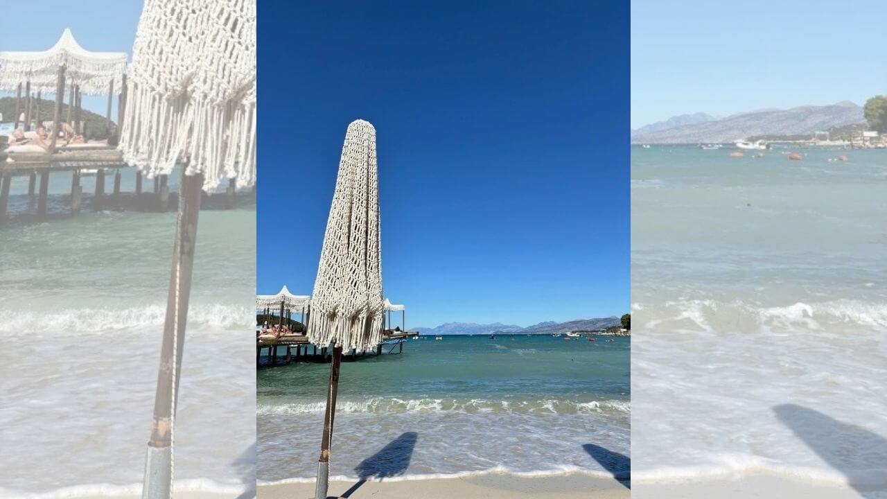 a beach umbrella on the shore of a body of water