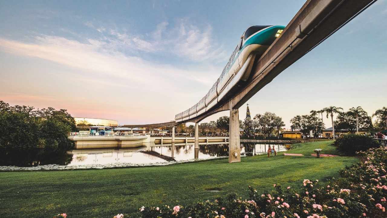 the disneyland monorail is suspended over a body of water