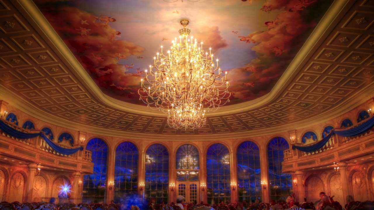 a large chandelier hangs from the ceiling of a ballroom