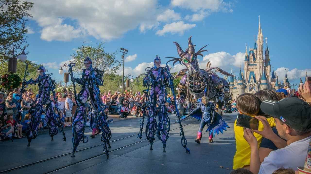 a group of people watching a parade in front of cinderella's castle