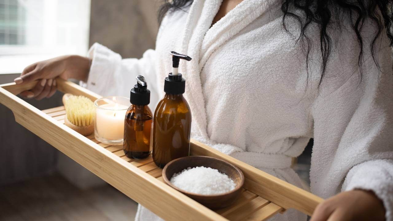 a person in a bath robe holding a tray with various products