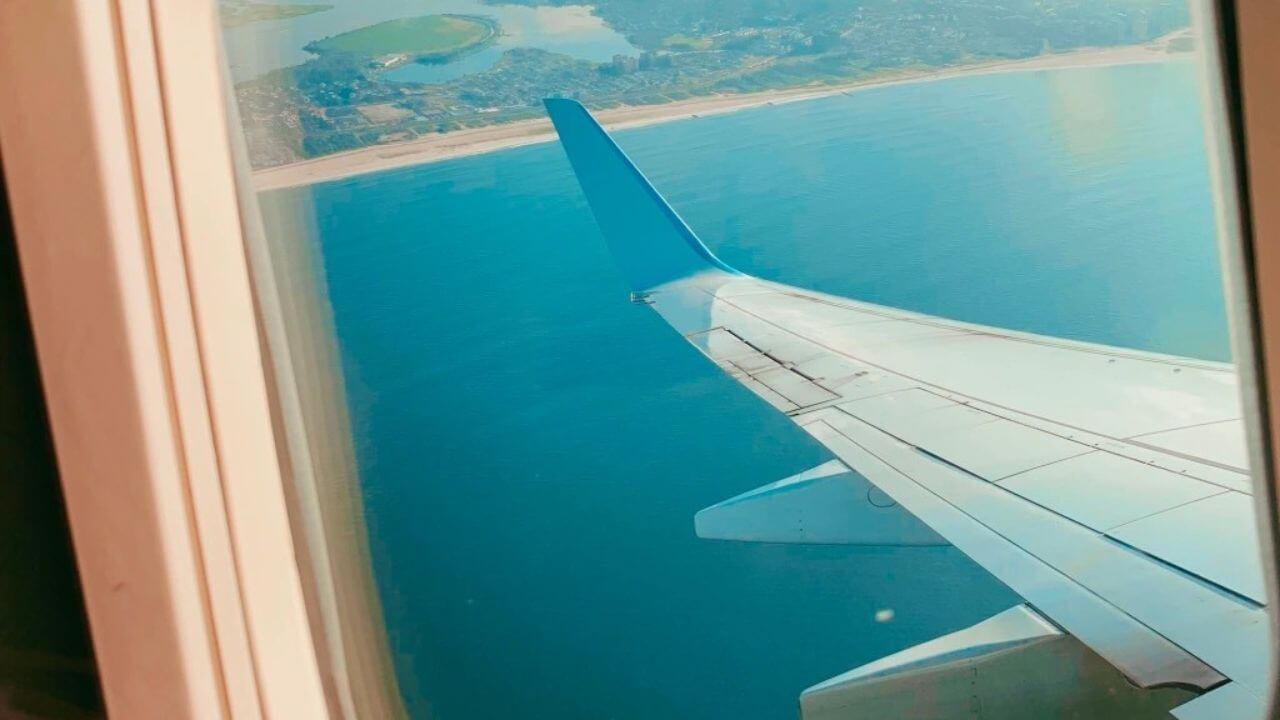 an airplane window with a view of the ocean