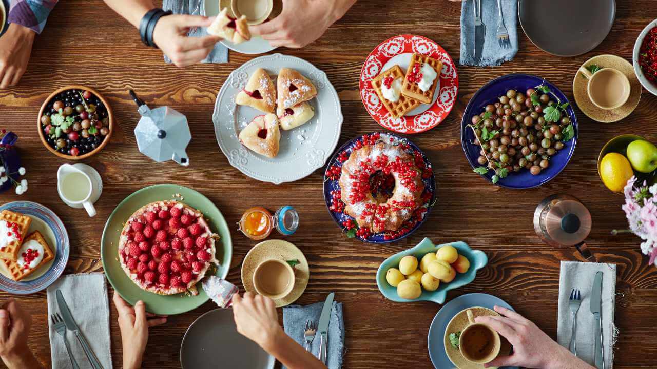 a group of people sitting around a table with plates of food