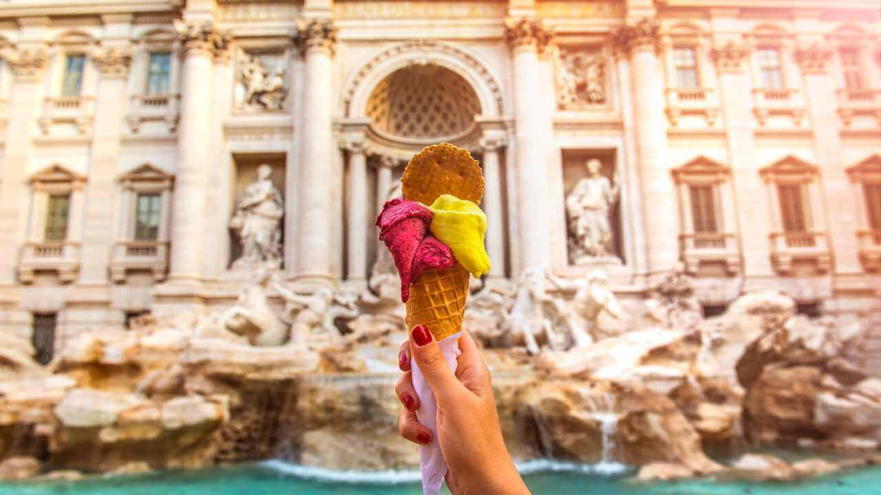 ice cream in front of trevi fountain in rome, italy