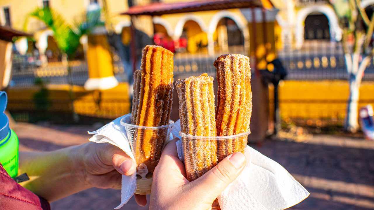 two people holding churros in their hands