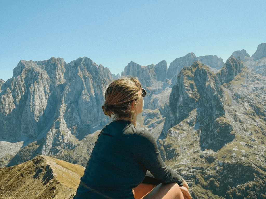 a person sitting on top of a mountain overlooking a valley