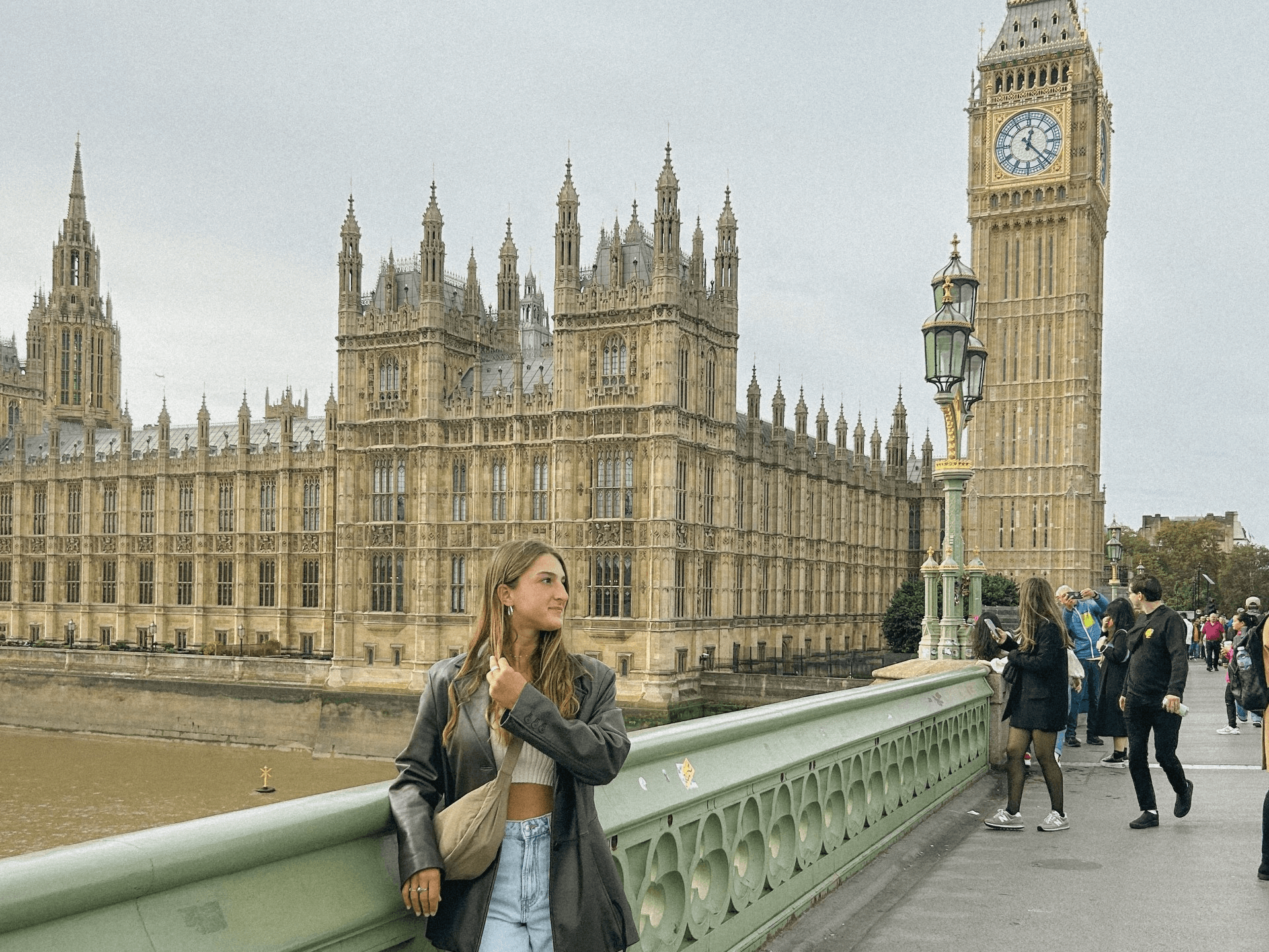 a girl standing near the big ben in london