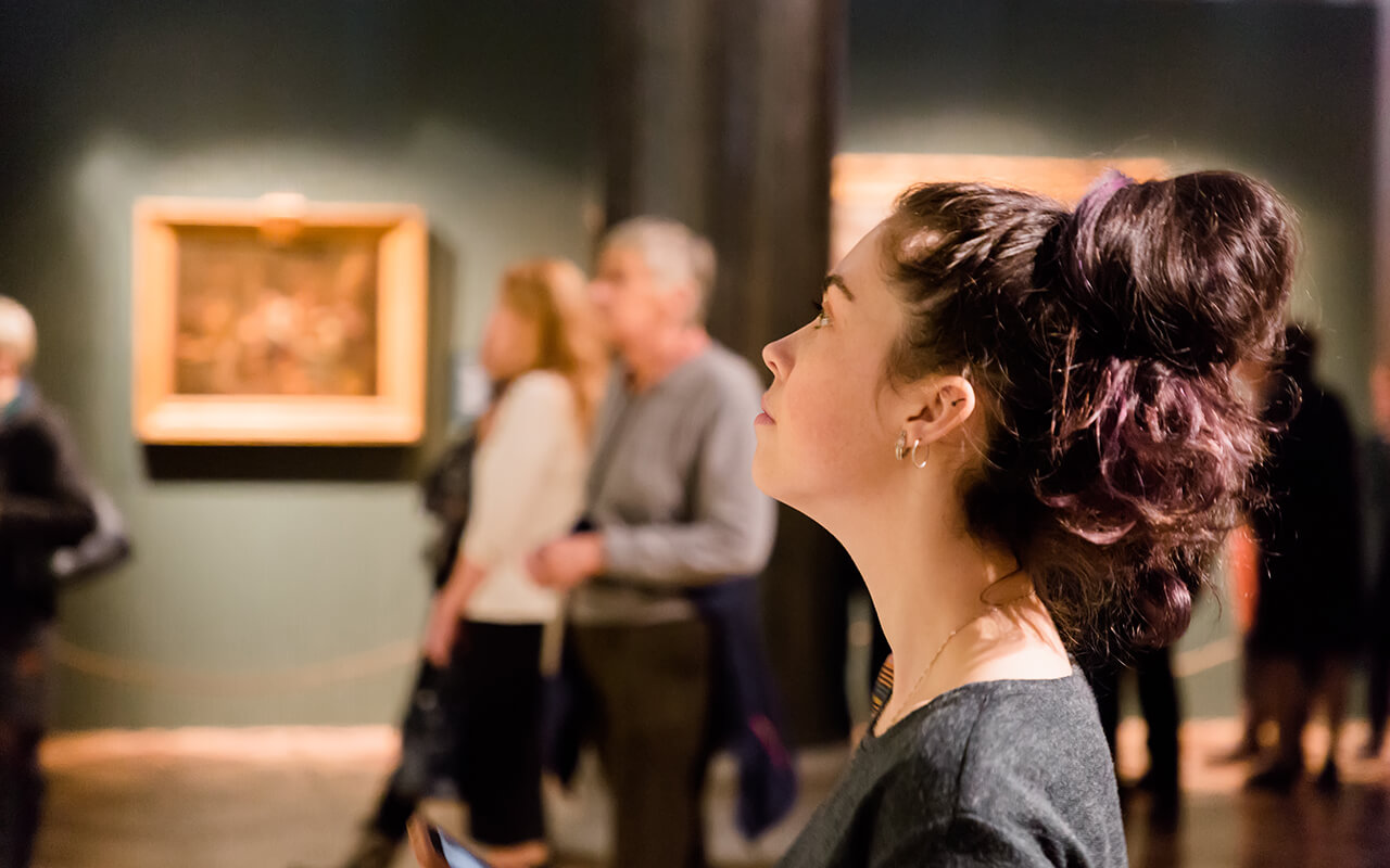 Woman in a crowded art gallery