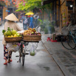 Woman walking in Hoi An with fruits