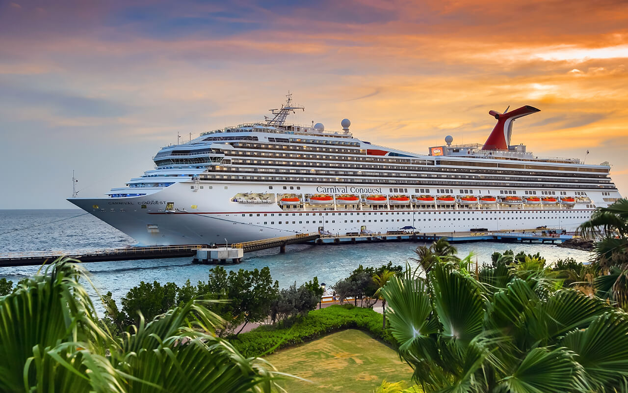 WILLEMSTAD, CURACAO - APRIL 04, 2018: Cruise ship Carnival Conquest docked at port Willemstad on sunset.