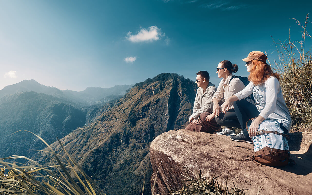 The company of young travelers look at the beautiful mountain peak "Adam's Peak" on the island of Sri Lanka.