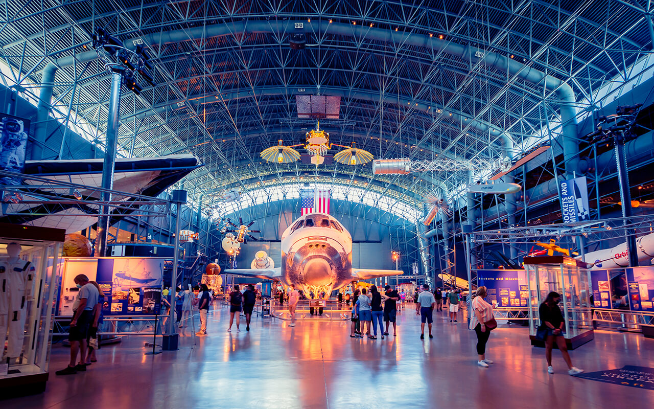 Visitors inside an aviation and space museum with a spacecraft exhibit, a great example of unique museums and quirky museums around the world