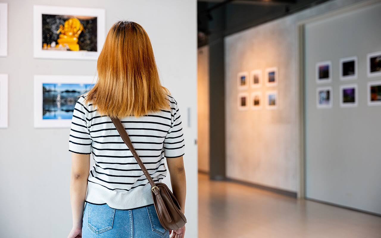 Woman standing in front of painting at gallery