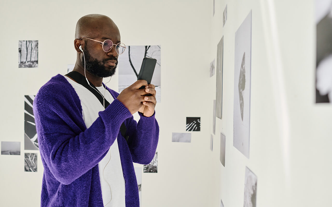 Man using a smart phone at a gallery