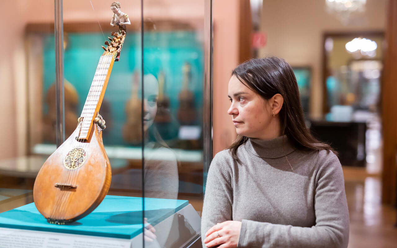 Woman looking at art piece in a clear display