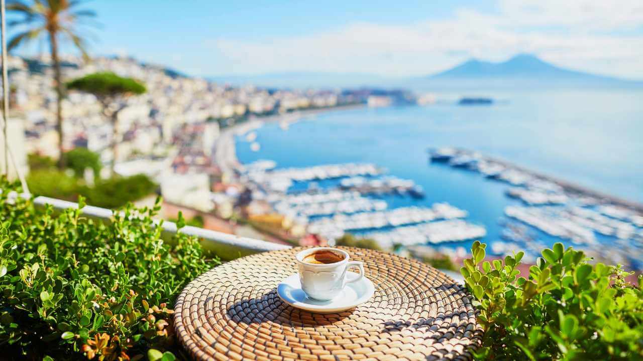 a cup of coffee on the terrace of a hotel overlooking the bay of naples, italy