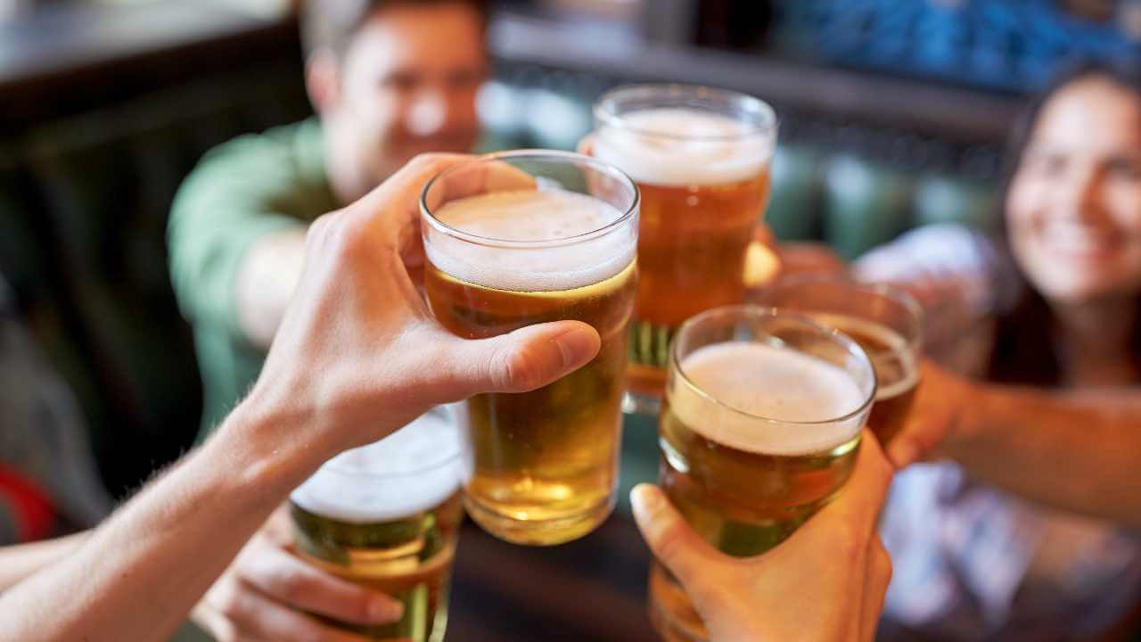 a group of people toasting with beer glasses