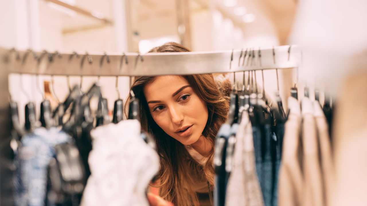 a person looking at clothes in a clothing store