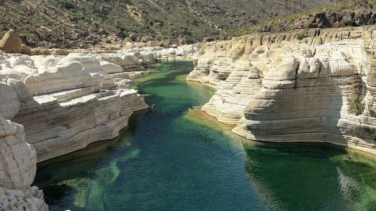 a river runs through a canyon in the middle of the desert