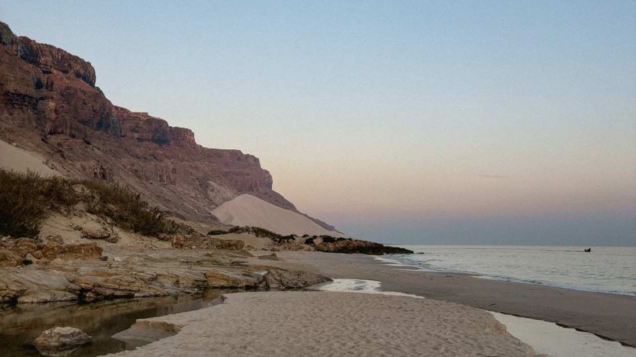 person sitting in the sand