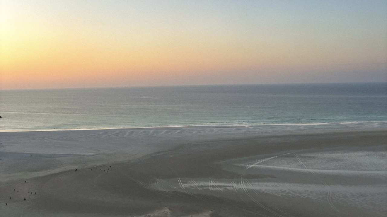 an aerial view of a beach at sunset