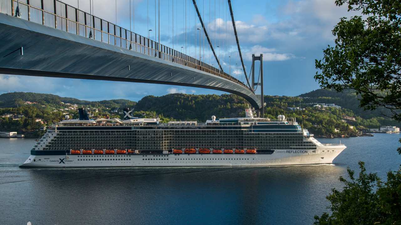 cruise ship under suspension bridge in norway