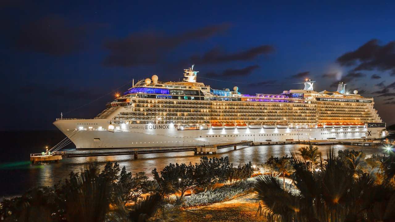 cruise ship lit up at night in the water