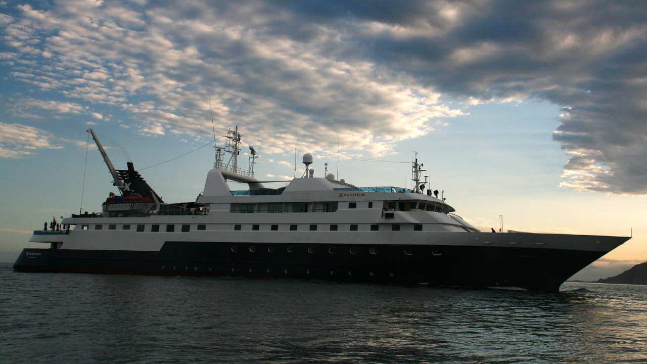 a large boat in the water with clouds in the sky