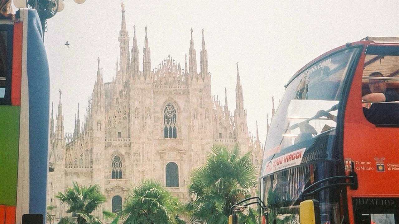 two double decker buses parked next to each other in front of a cathedral